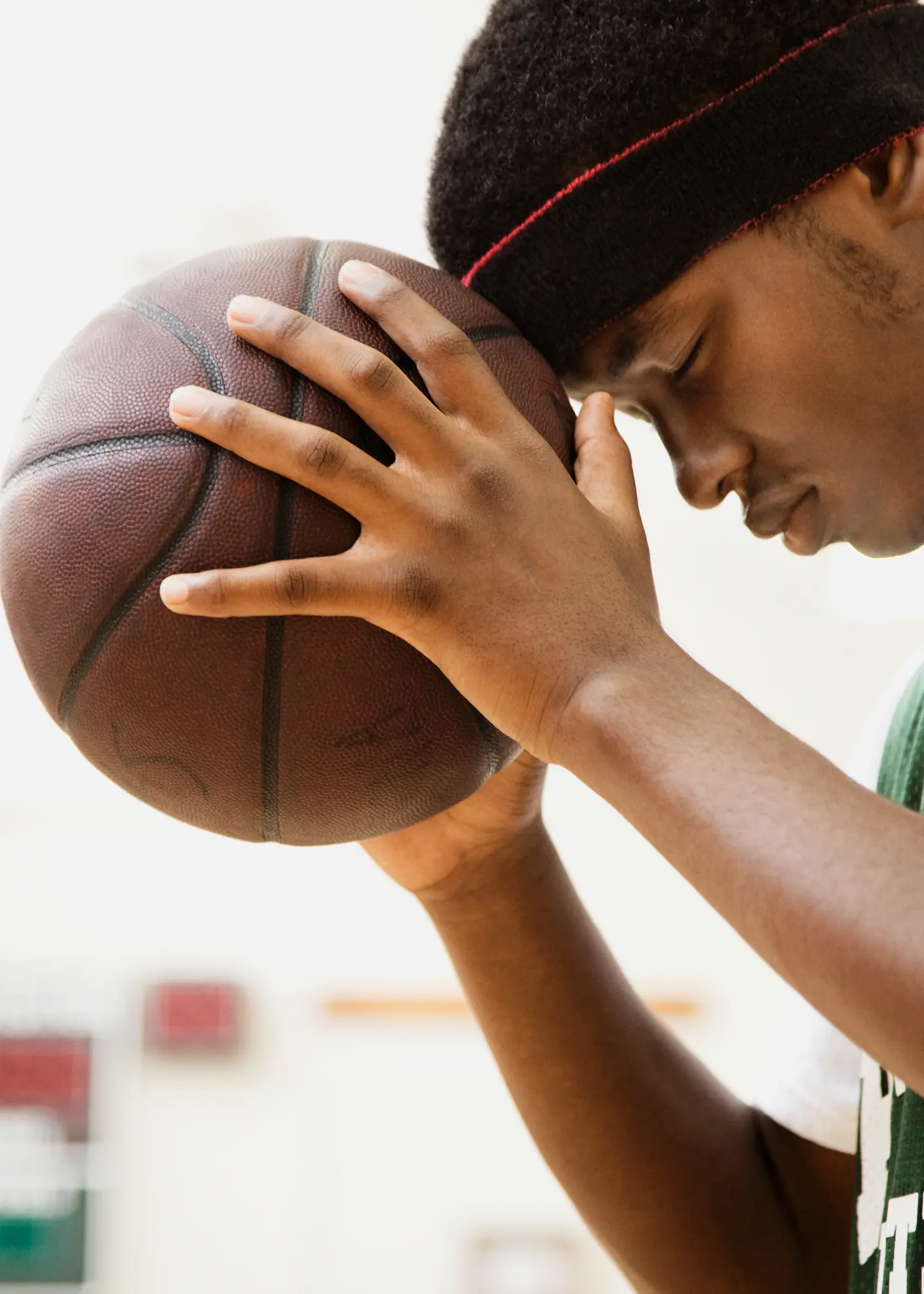 Ein junger Mann hält einen Basketball in den Händen