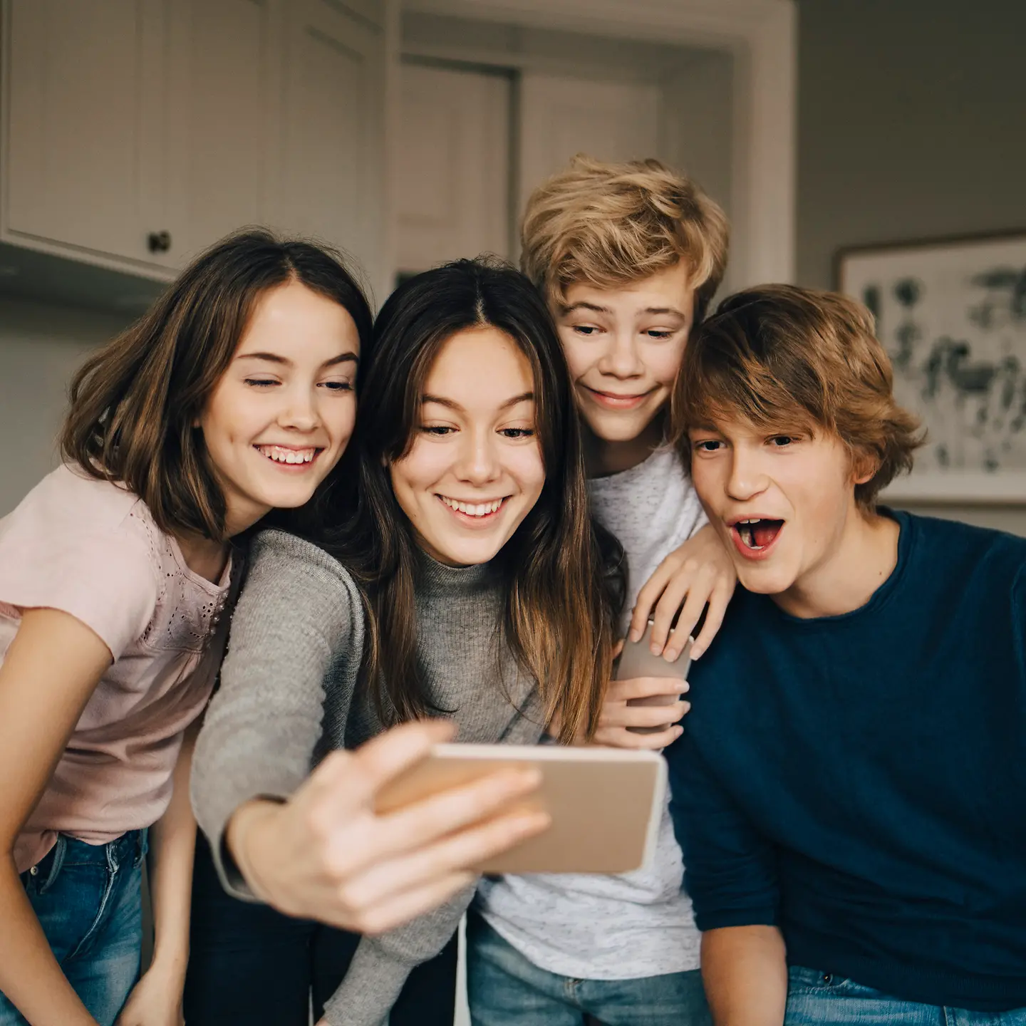 Eine Gruppe Jugendlicher schaut in ein Smartphone