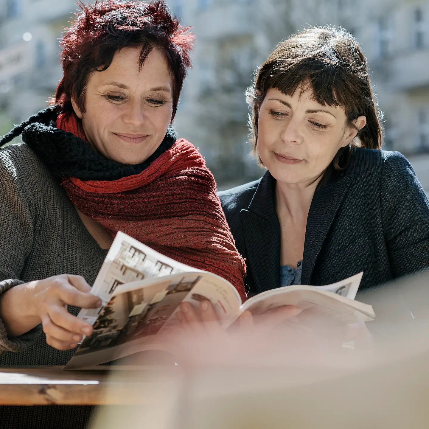 Zwei Frauen schauen gemeinsam in eine Zeitschrift