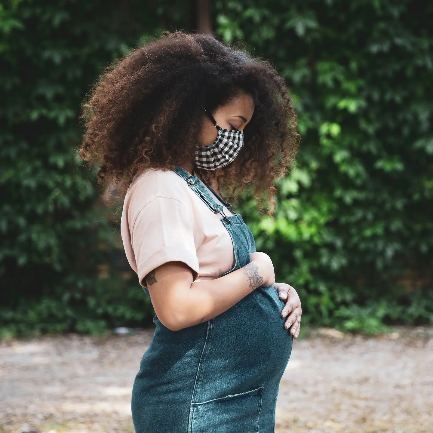 Schwangere Frau trägt eine Atemmaske aus Stoff