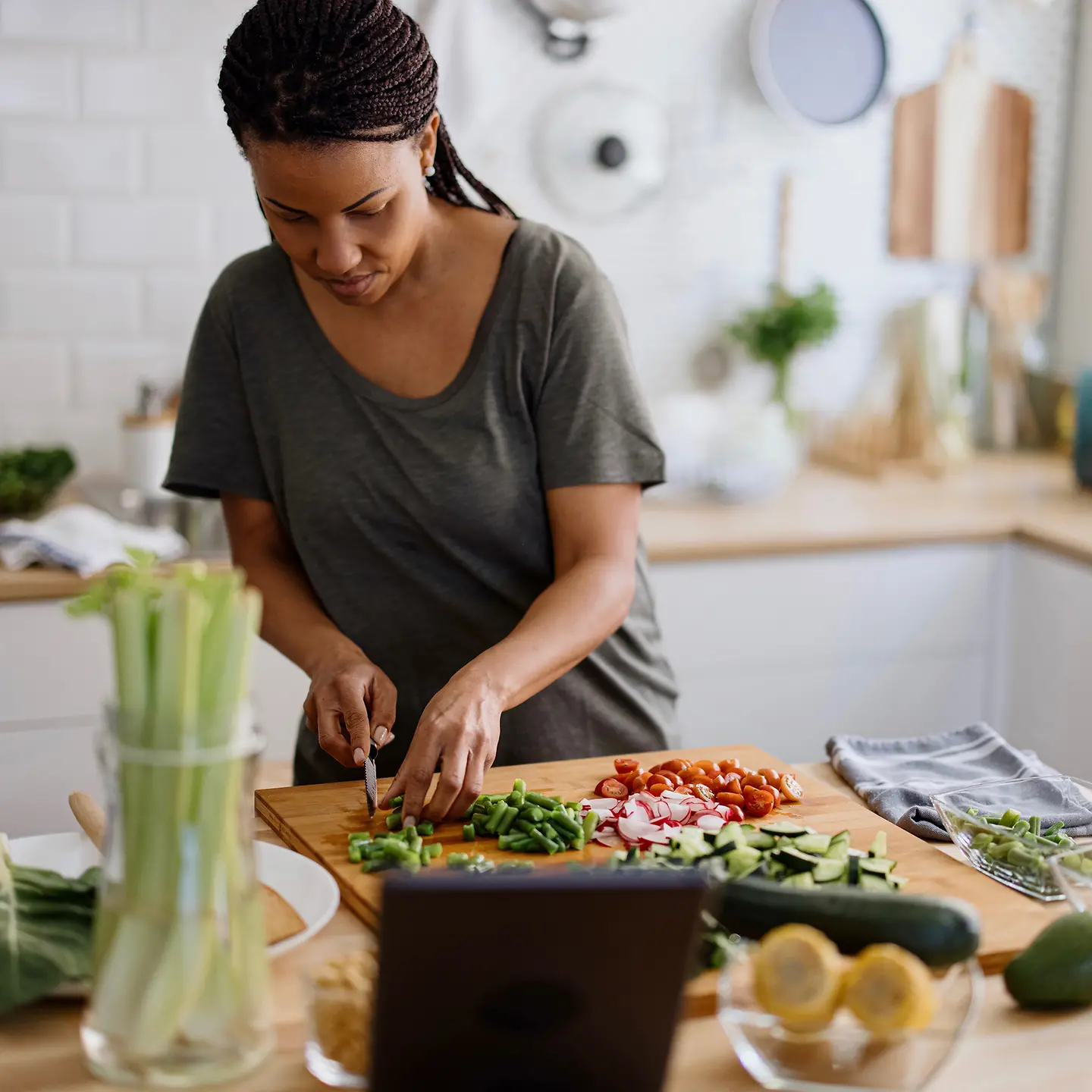 Eine Frau schneidet in ihrer Küche Gemüse klein
