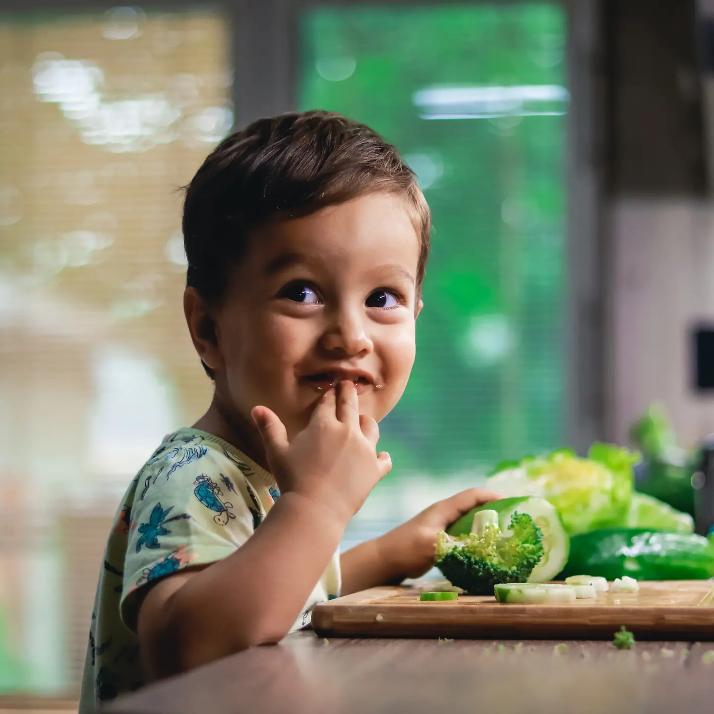 Ein kleiner Junge isst Rohkost-Gemüse