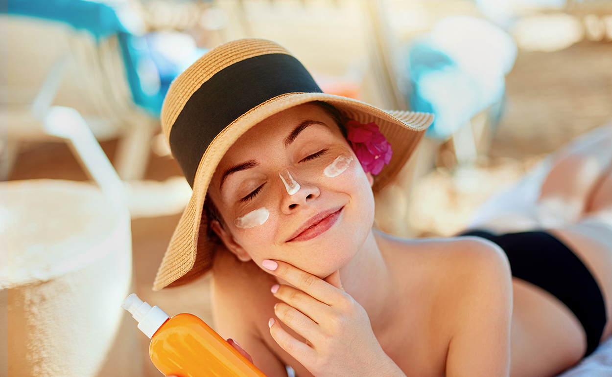 Eine Frau mit Hut liegt in der Sonne