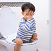 Kind sitzt auf Toilette