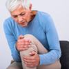 Ältere Frau hält schmerzendes Knie