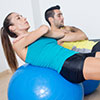 Frau und Mann trainieren auf Gymnastikbällen