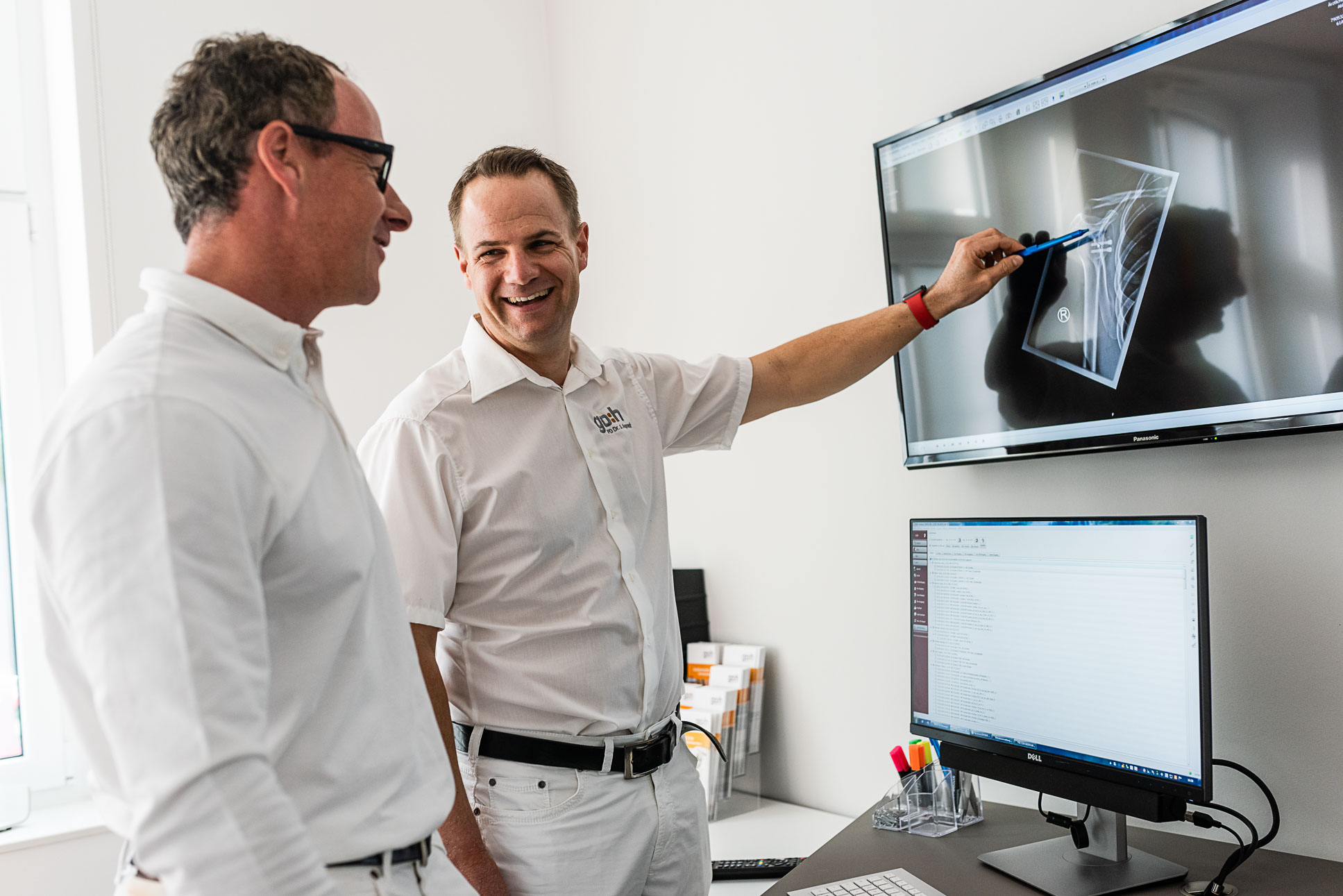Markus Tröger und Jens Agneskirchner schauen auf dem Bildschirm ein Röntgenbild an