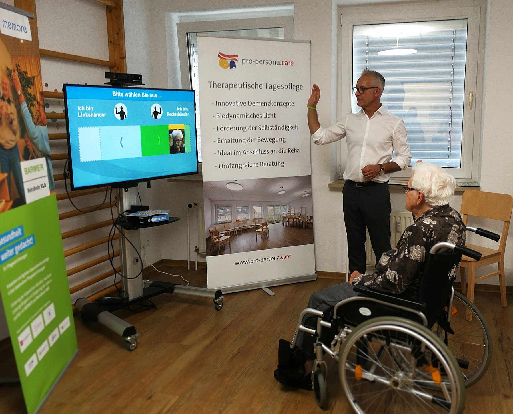 Ein Senior sitzt im Rollstuhl vor einem Bildschirm