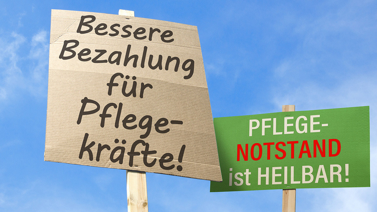 Auf Plakaten werden bessere Bezahlung und mehr Personal in der Pflege gefordert