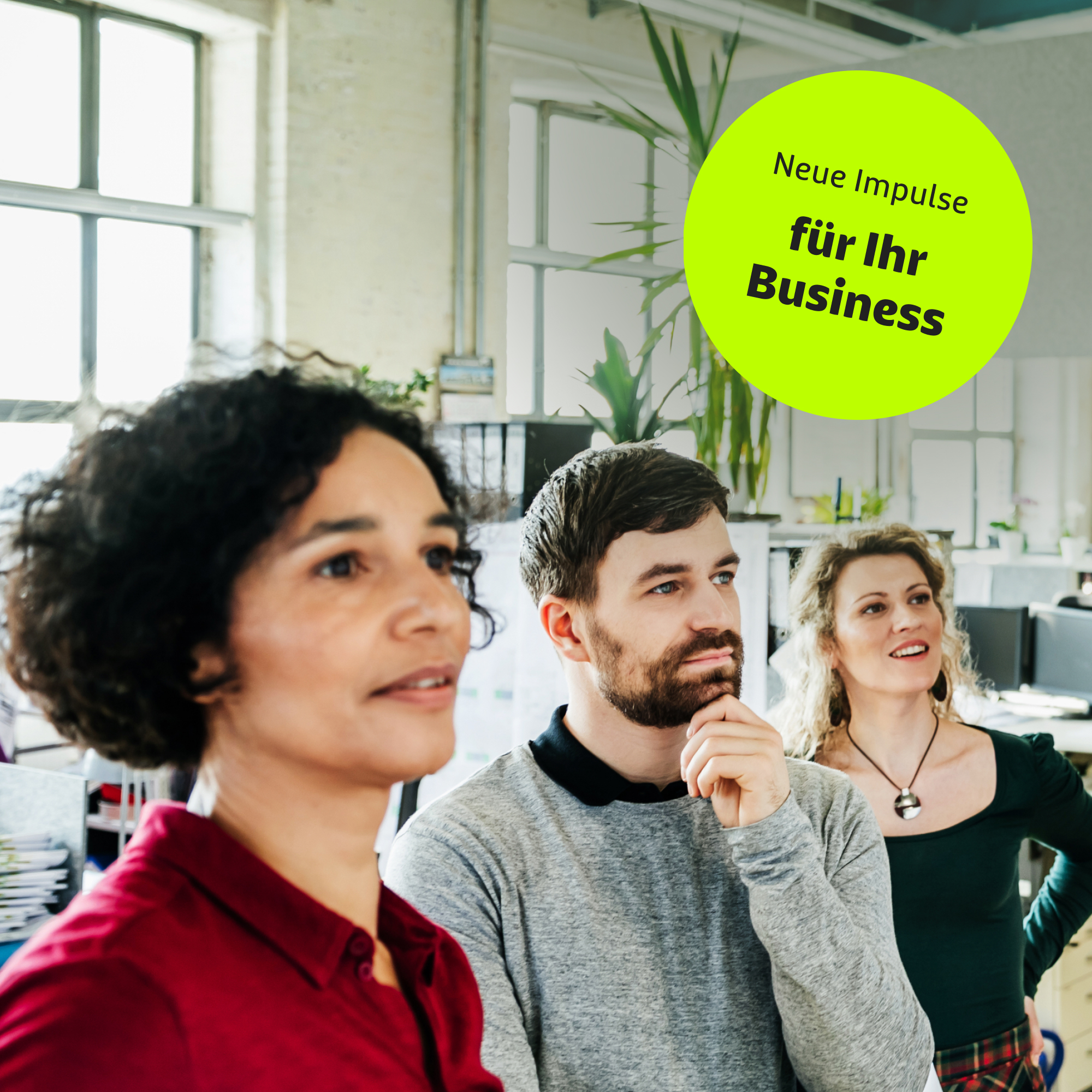 Ein Team steht vor einer Präsentationswand und diskutiert