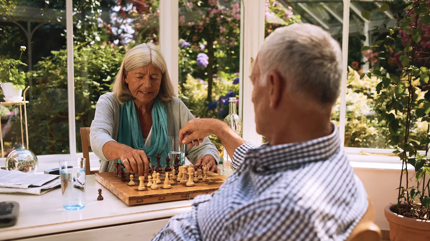 Zwei ältere Menschen spielen Schach