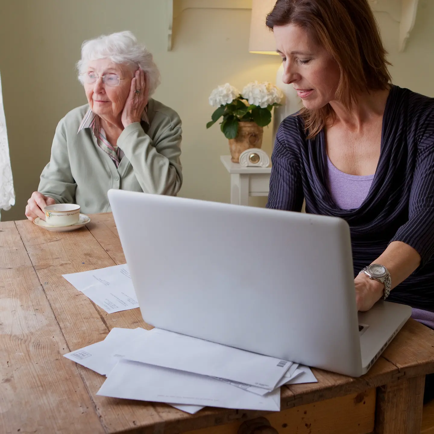 Eine pflegende Angehörige bedient einen Laptop
