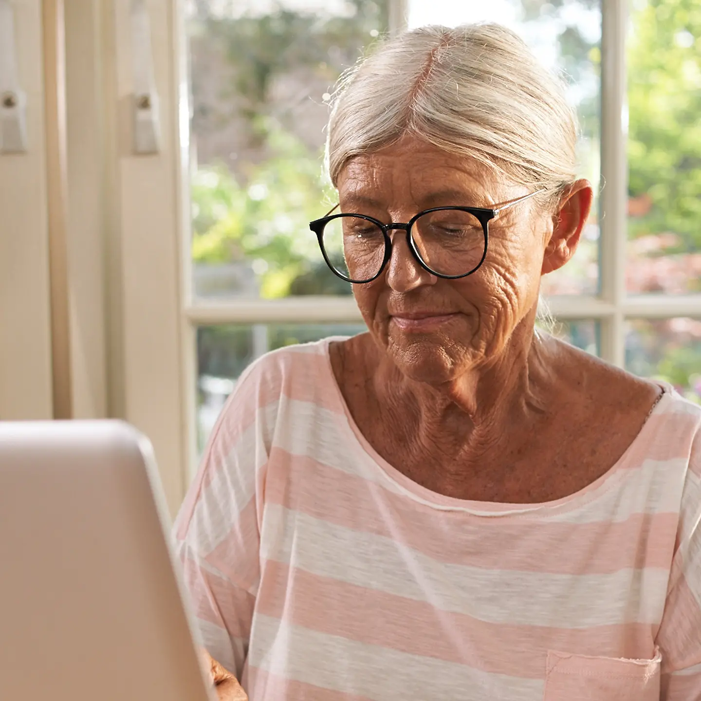 Ältere Frau sitzt vor einem Notebook