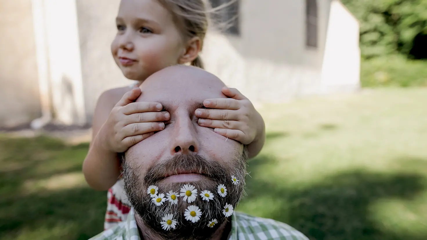 Mann mit Blumen im Bart und seine kleine Tochter
