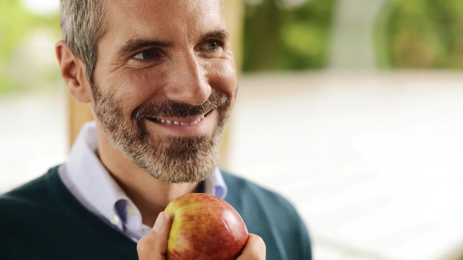 Ein Mann hält einen Apfel in der Hand
