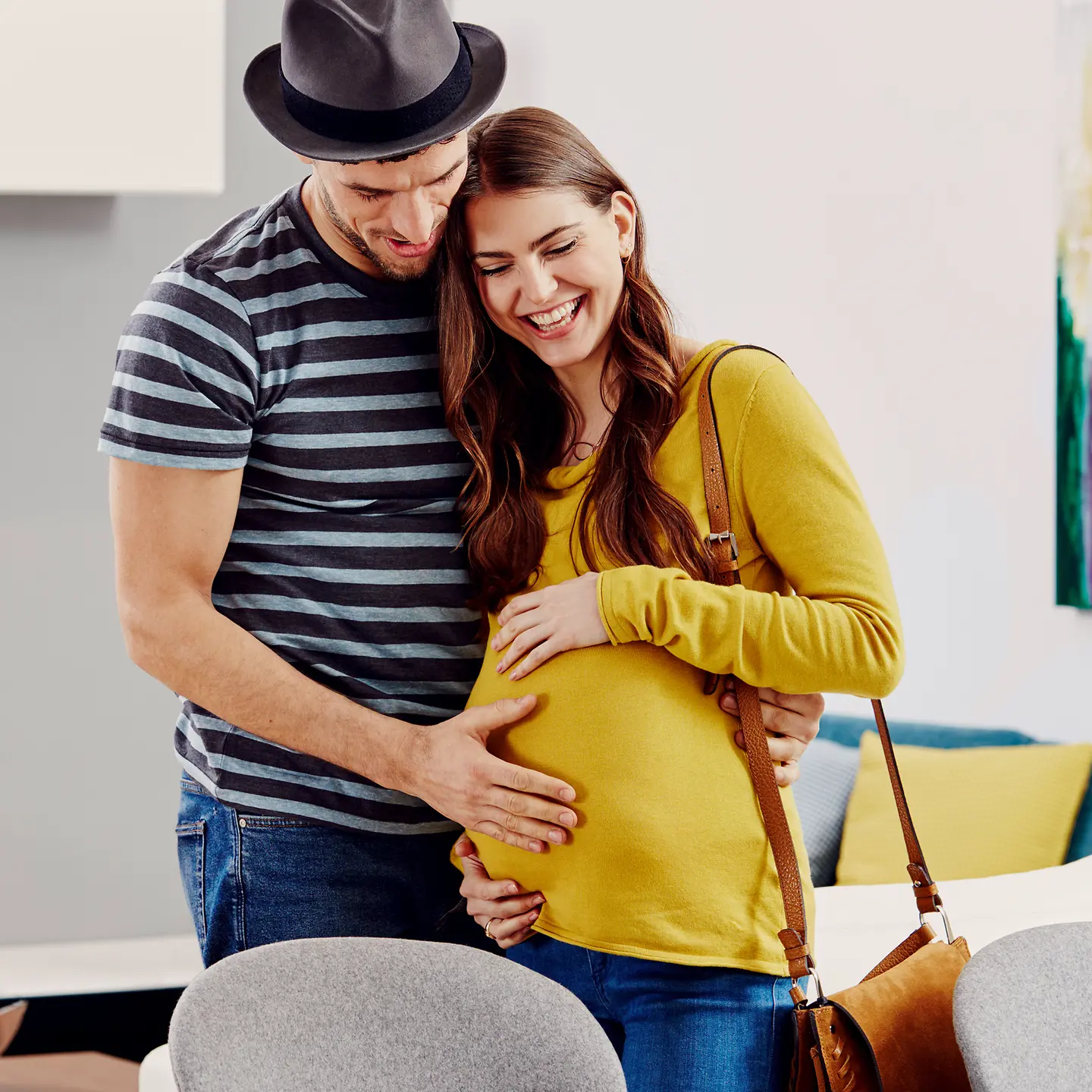 Eine Schwangere lächelt mit den Händen auf ihrem Bauch