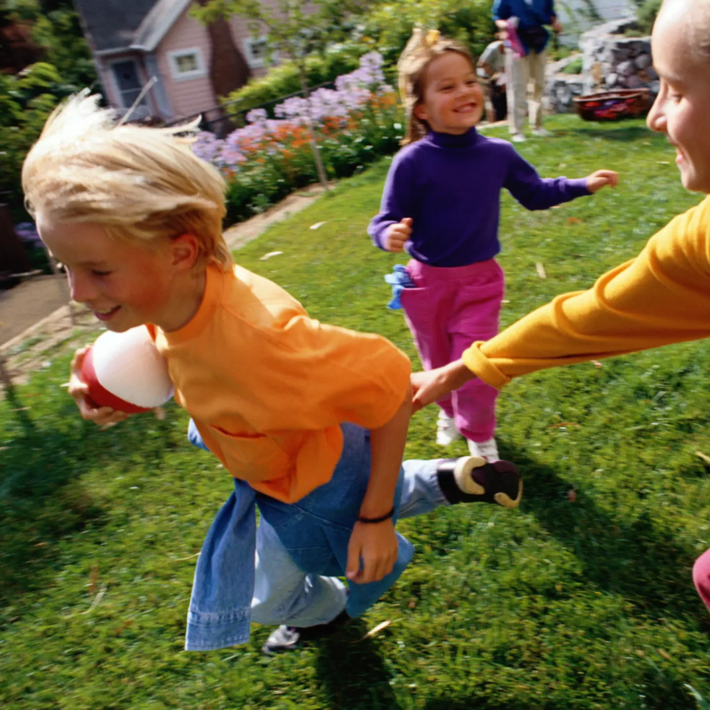 Kinder spielen auf dem Rasen mit einem Ball