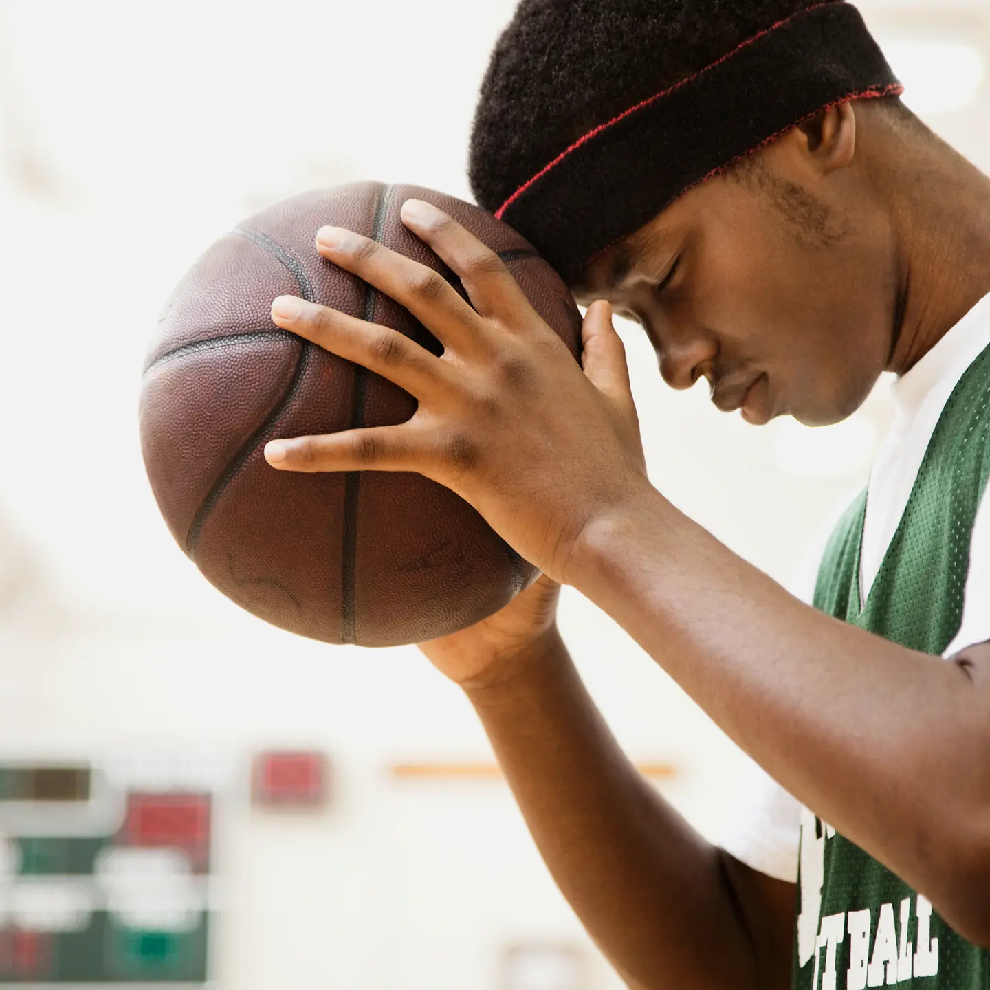 Ein junger Mann hält einen Basketball in den Händen