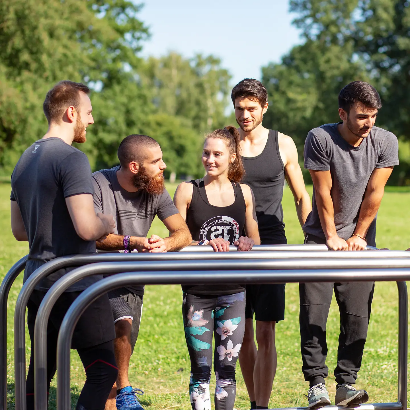 Junge Sportler im Park hinter Stangen.