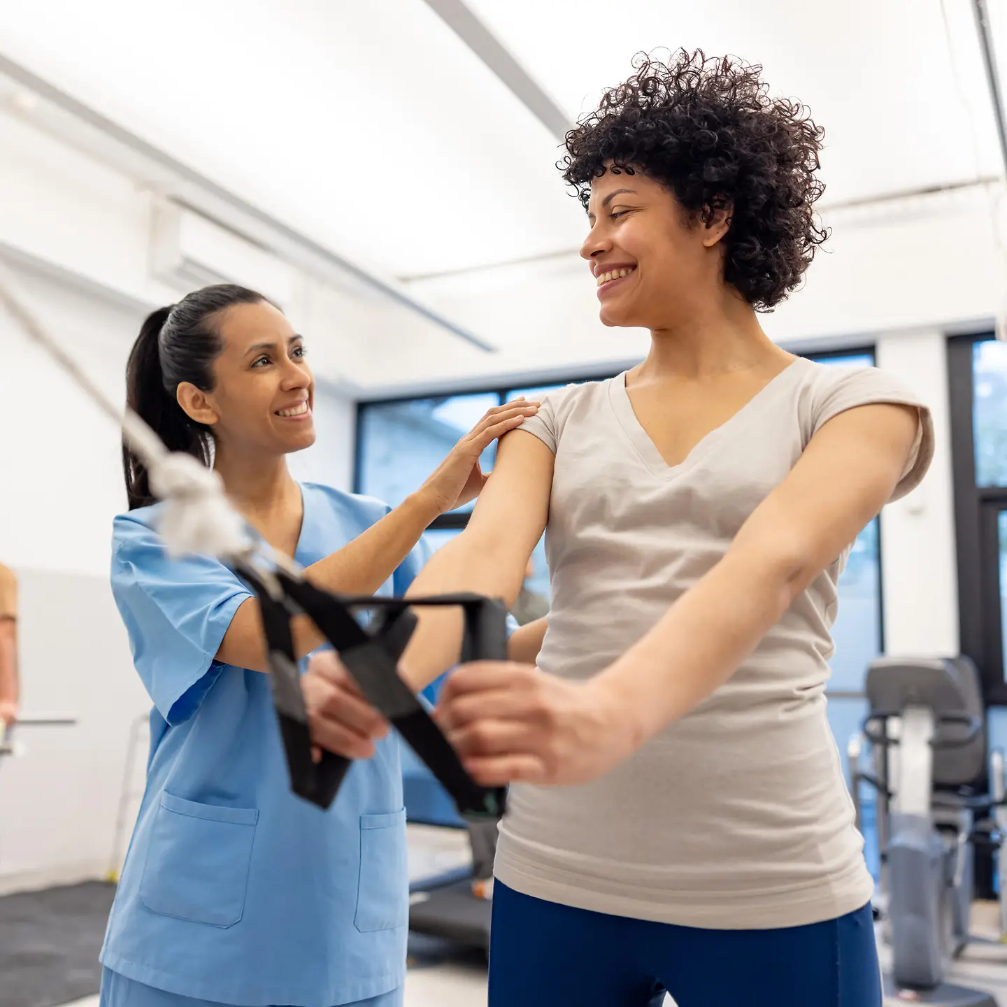 Eine Frau in der Physiotherapie macht Übungen auf einer Zugmaschine.