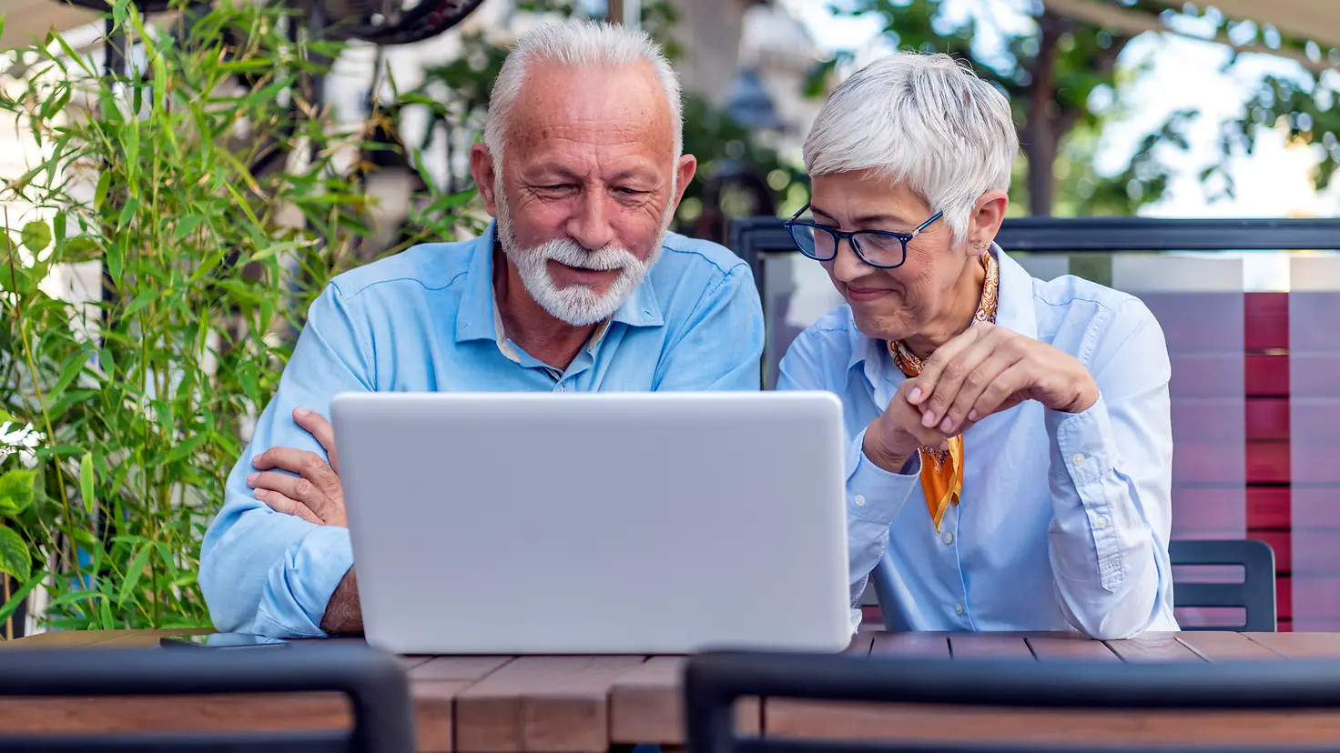 Seniorenpaar schaut auf ein Laptop