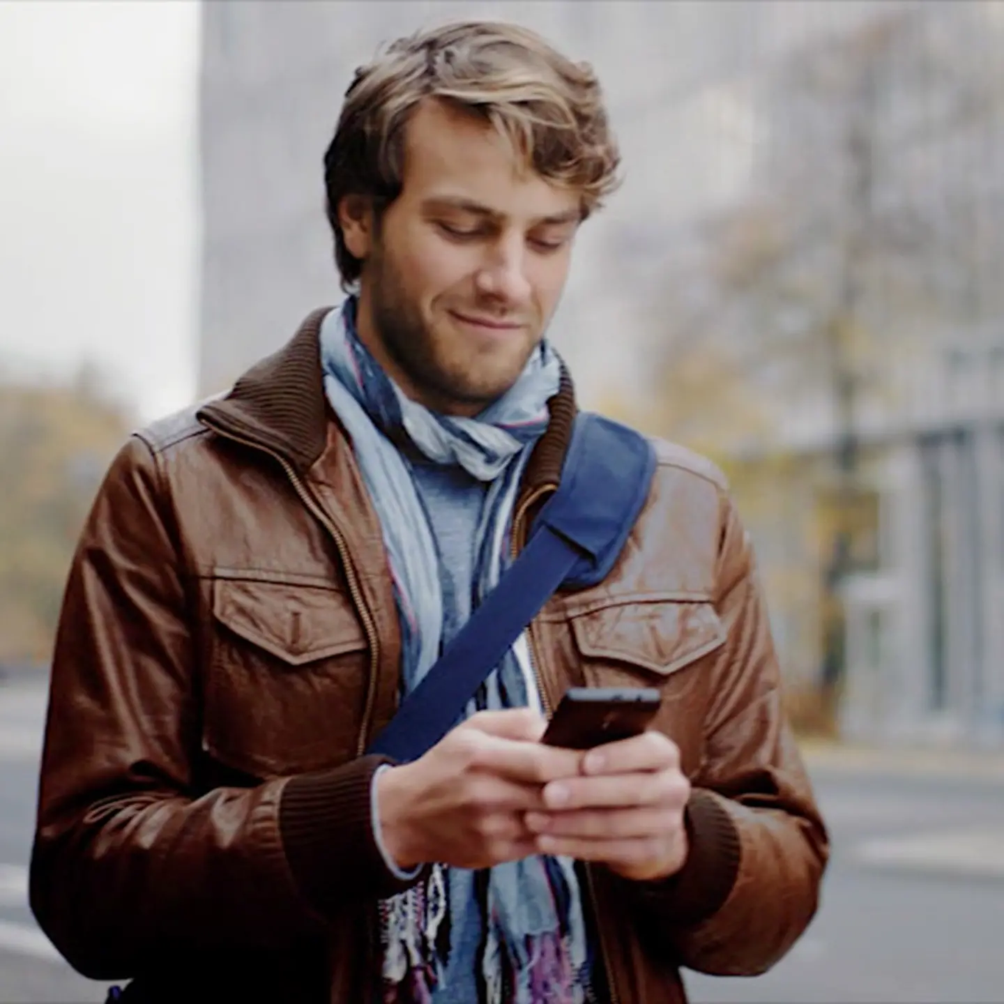 Mann schaut an einer Ampel auf sein Smartphone