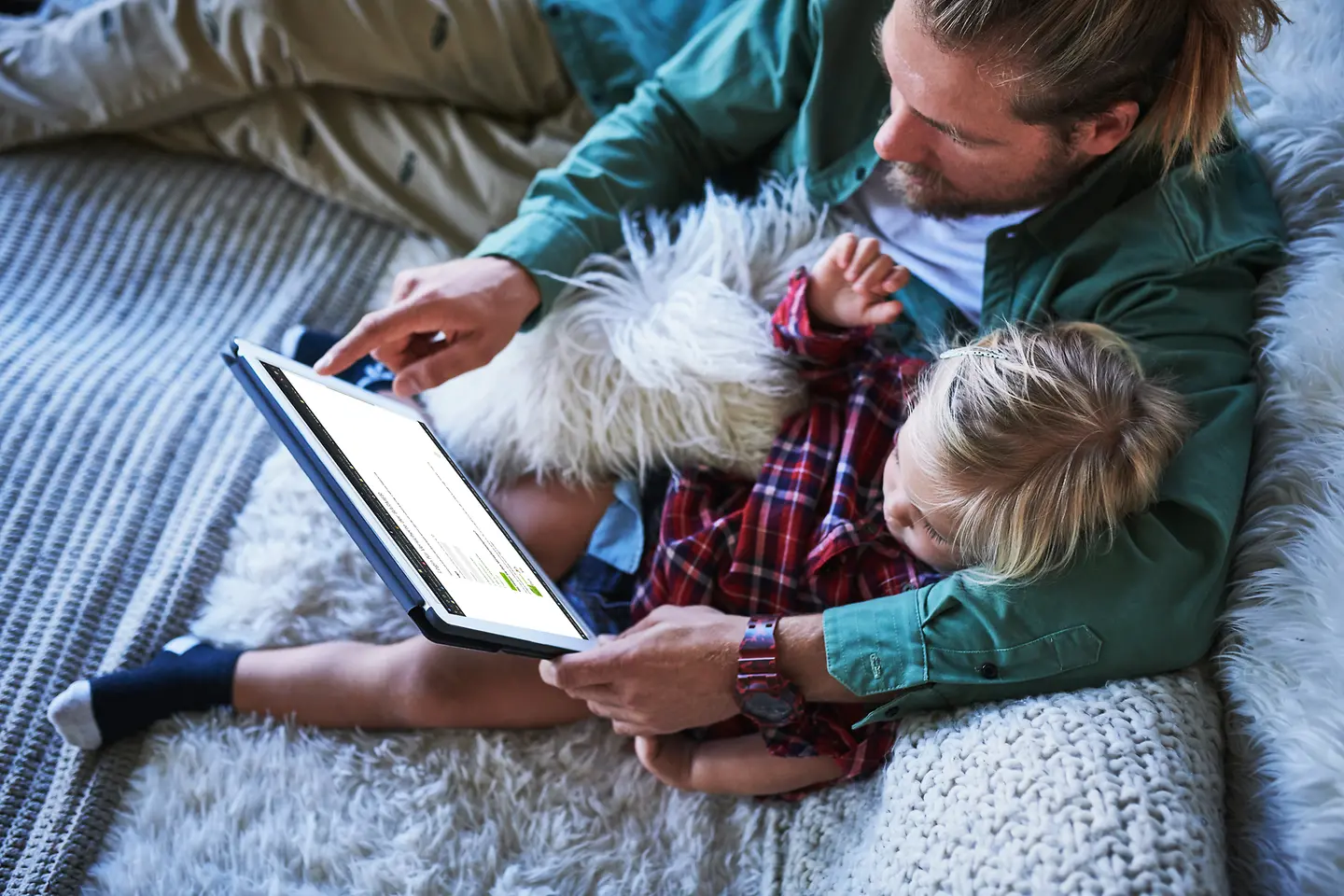 Vater und Sohn mit Tablet auf der Couch