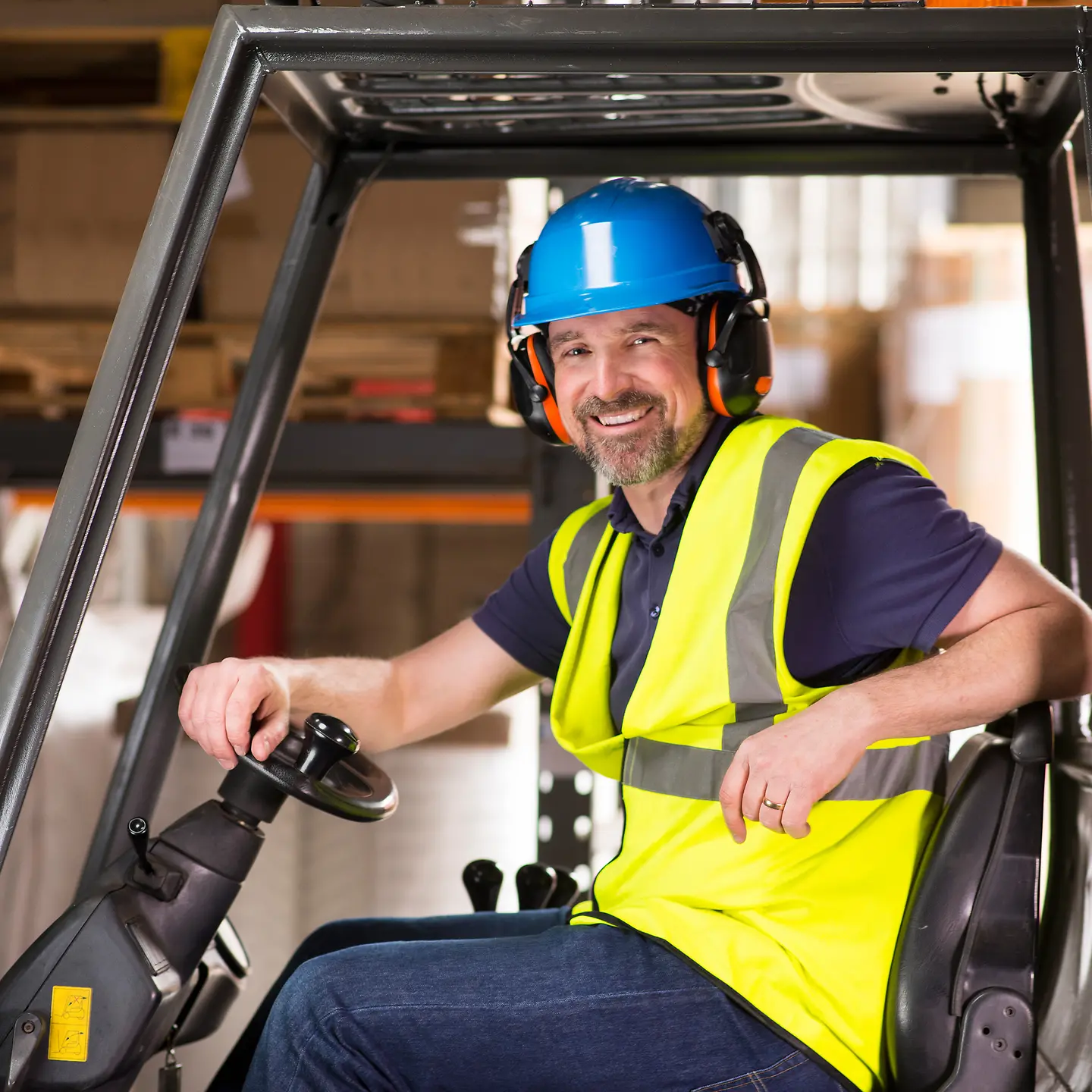 Ein Staplerfahrer auf einem Stapler in einer Lagerhalle