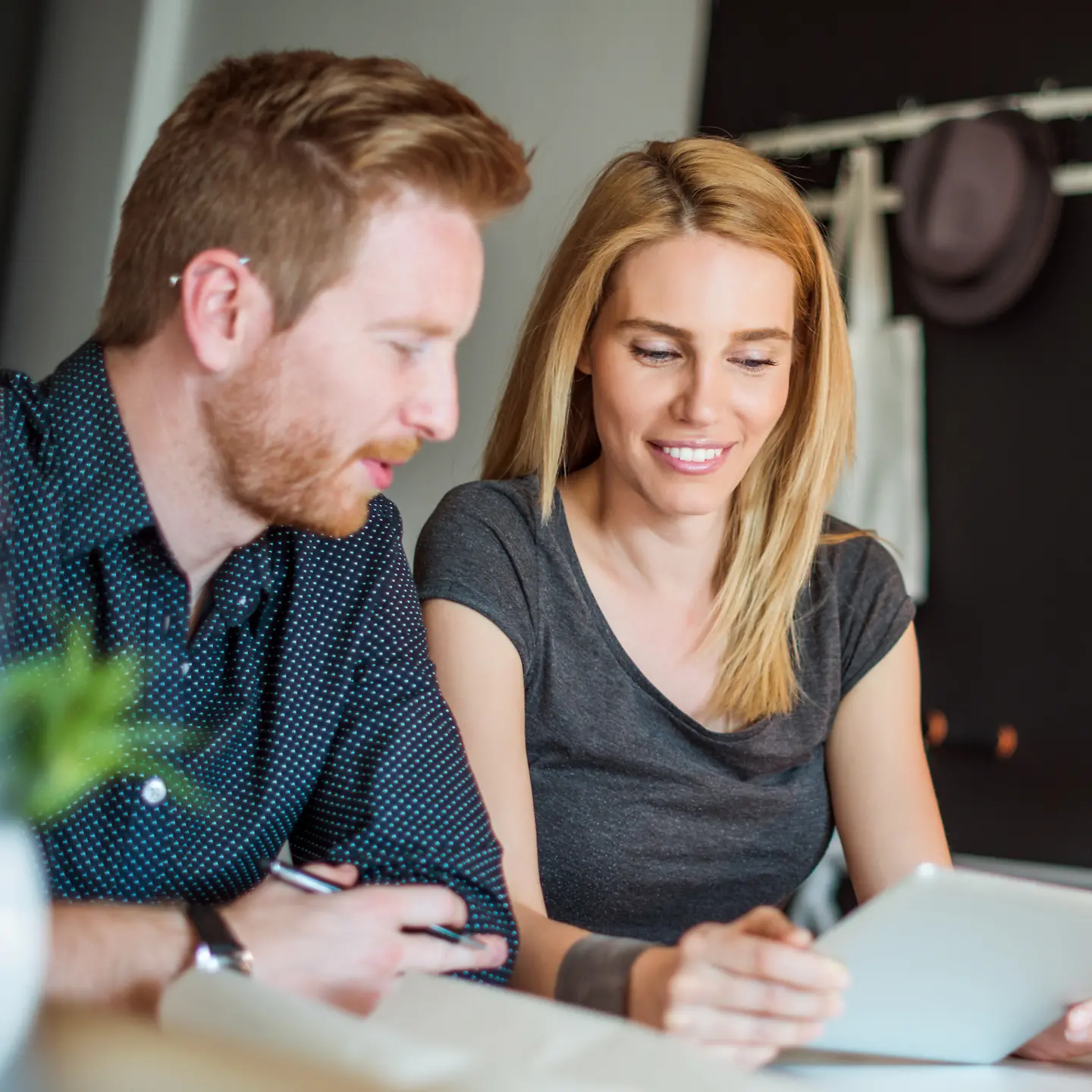 A young couple at the office looking at a tablet