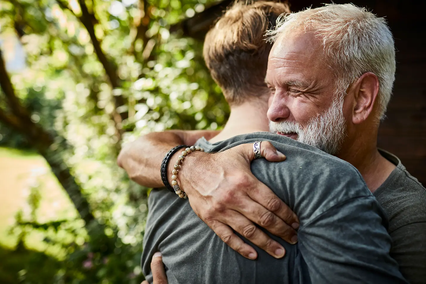 Mann umarmt eine andere Person