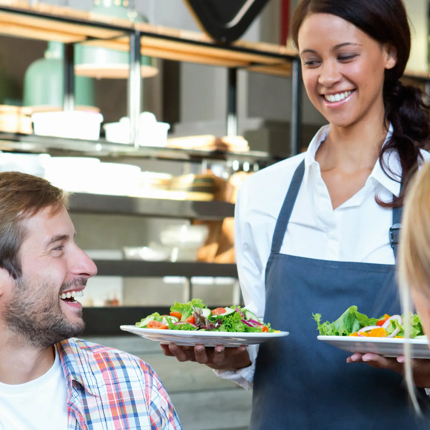 Eine junge Kellnerin serviert einen Salat