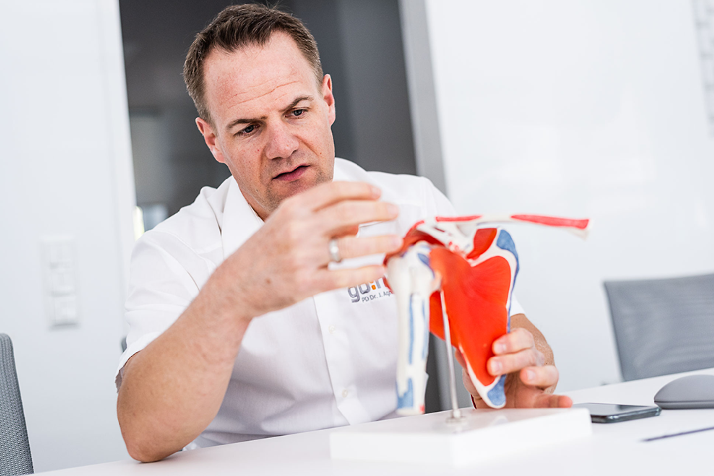 Jens Agneskirchner betrachtet ein Gelenkmodell