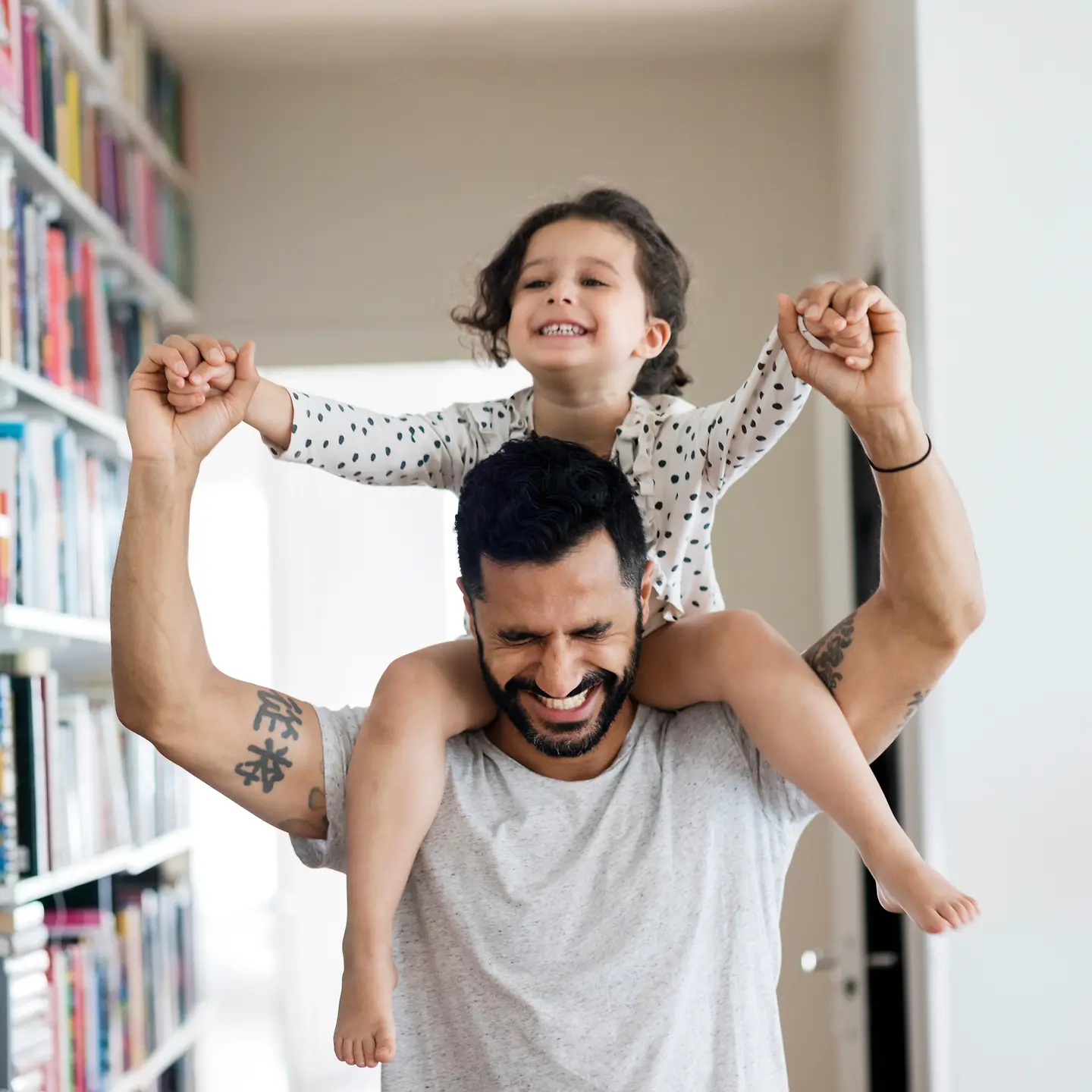 Ein Vater trägt seine Tochter auf den Schultern