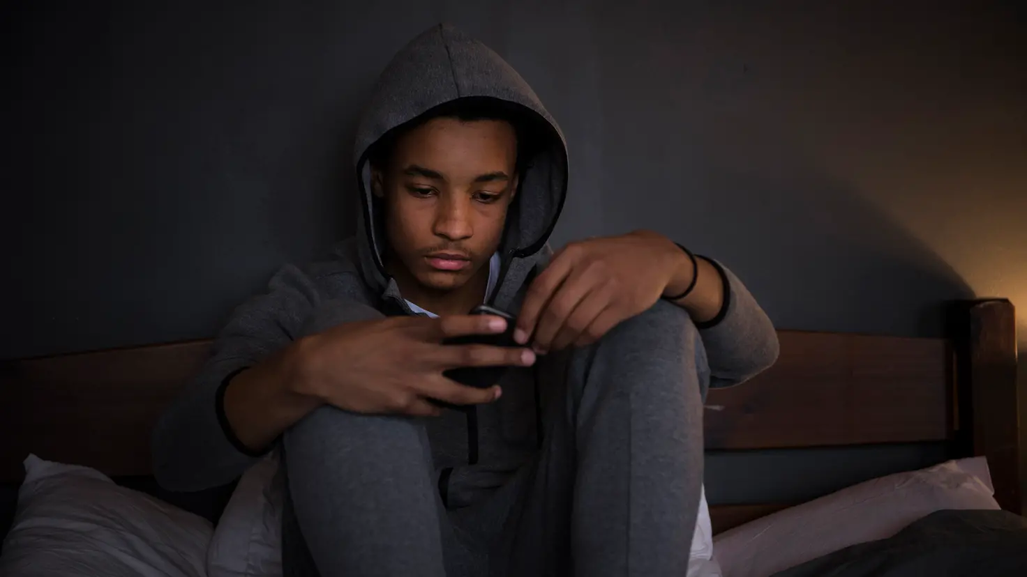 Teenager schaut auf sein Smartphone