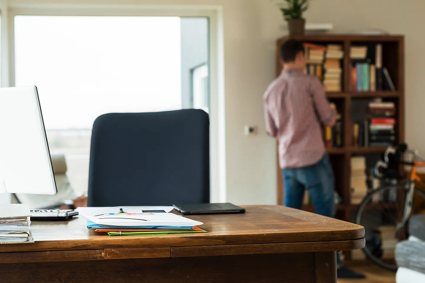 Student in seiner Wohnung mit Bücherregal und PC