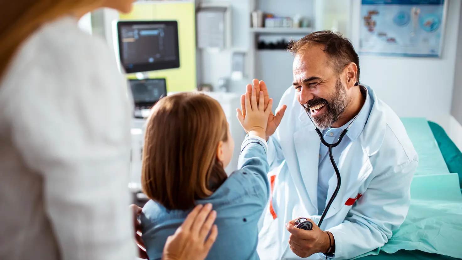 Ein Arzt gibt seiner jungen Patientin ein "High Five"