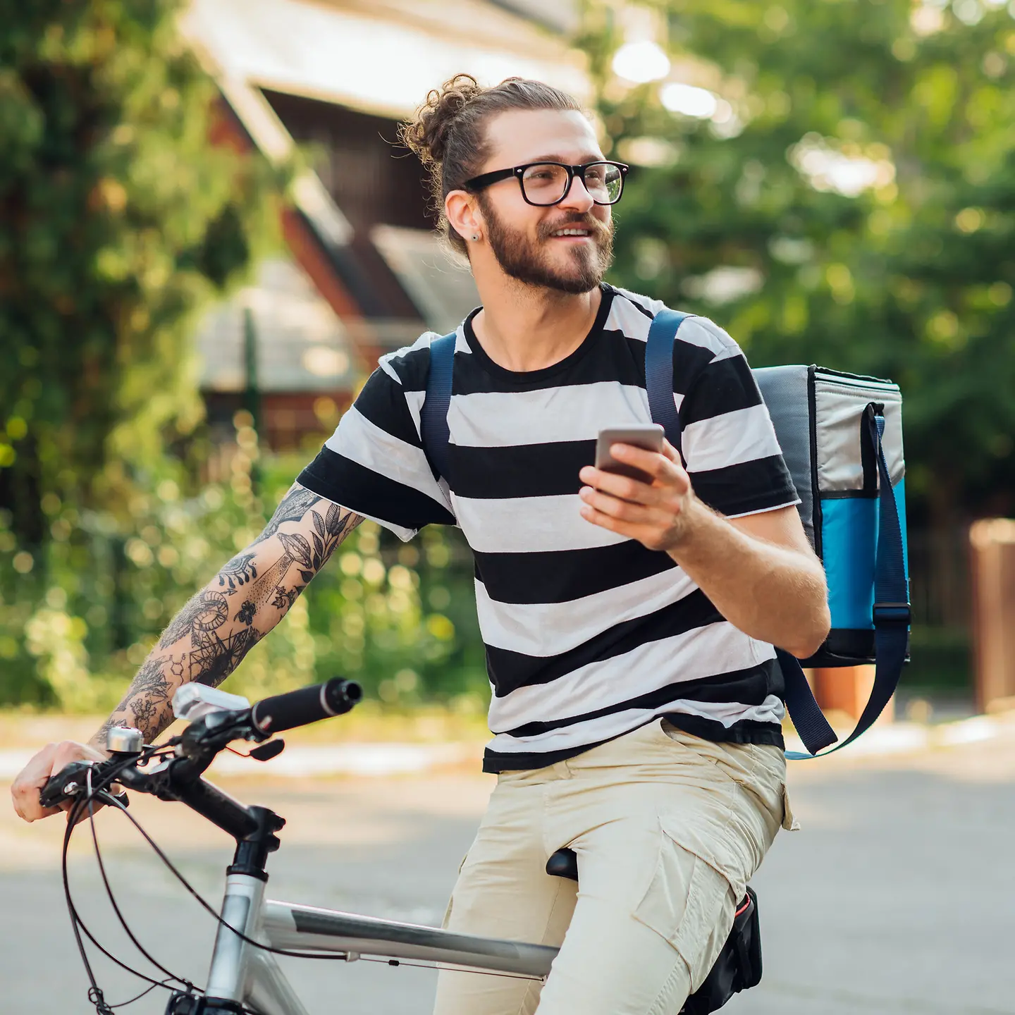 Ein junger Mann mit Fahrrad fährt Pakete aus