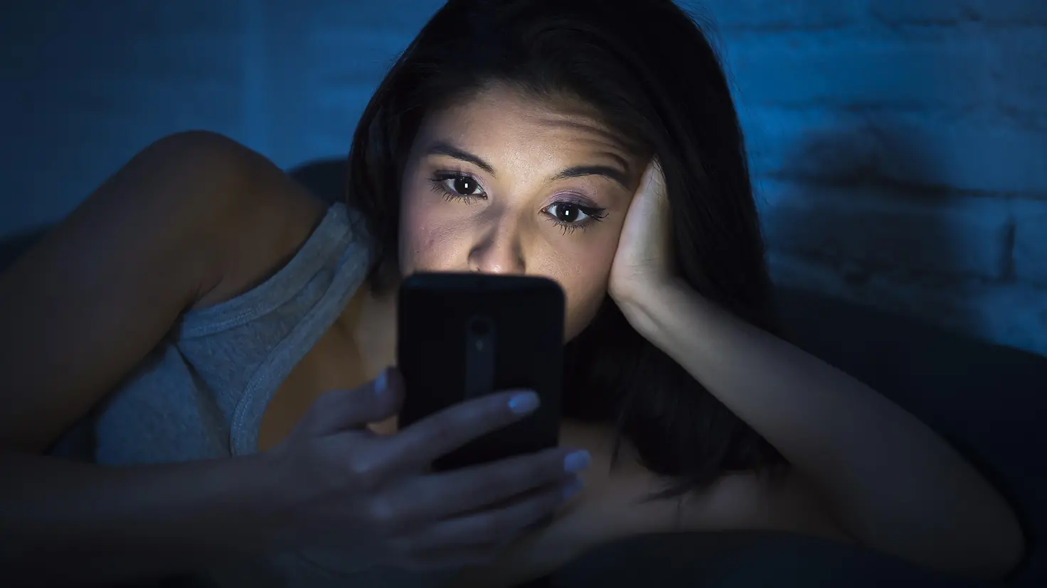 Eine Frau schaut nachts aufs Handy