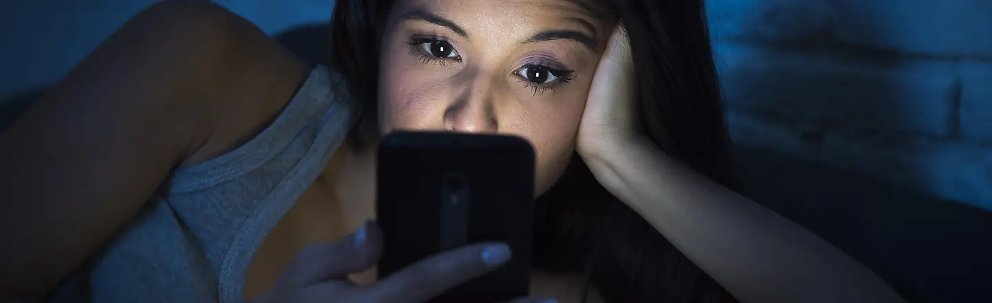 Eine Frau schaut nachts aufs Handy