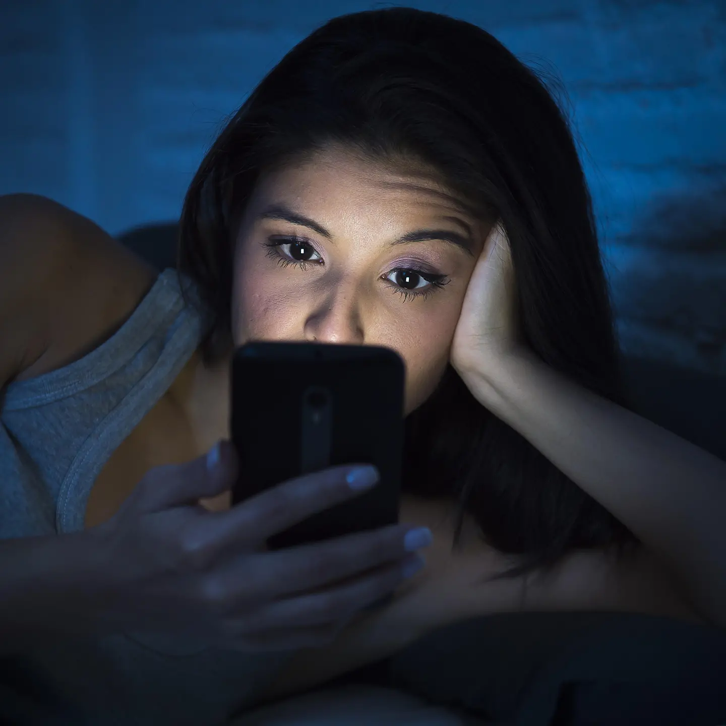 Eine Frau schaut nachts aufs Handy