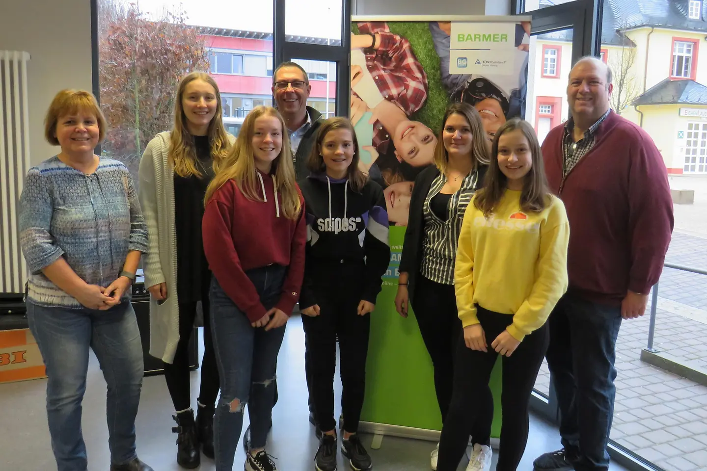 Digi Camp Weiskirchen: Lehrer und Schüler stehen vor einer Wand