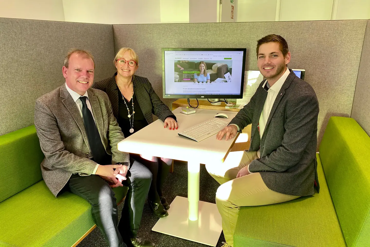 Drei Personen sitzen in einer Beratungsecke in der Barmer Geschäftsstelle Alzey