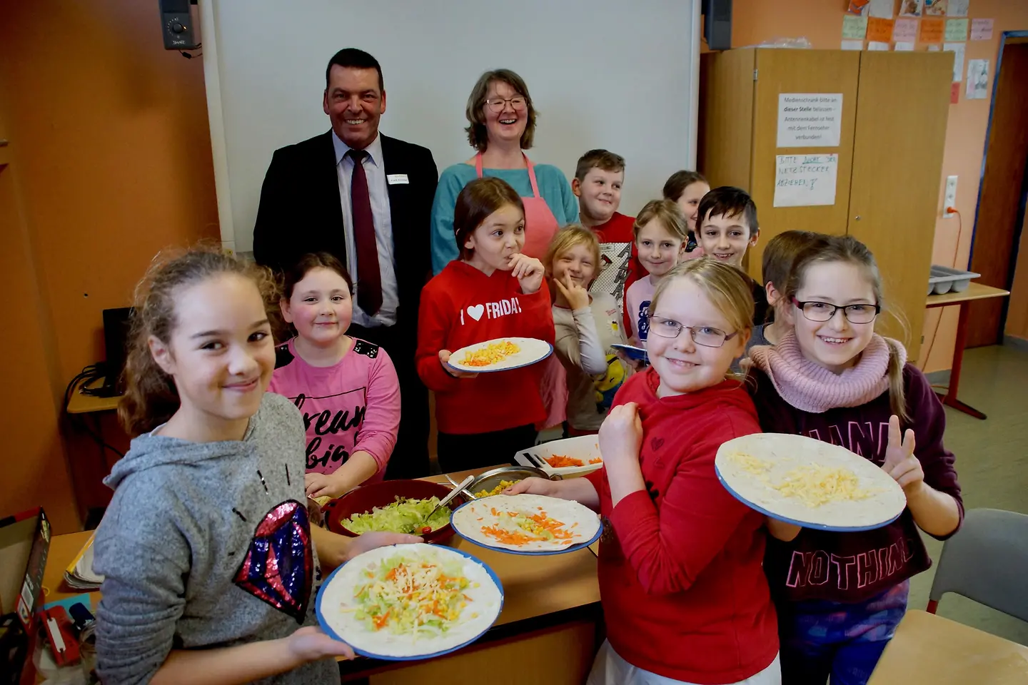 Genussbotschafterin Margit Weyandt und Barmer-Regionalgeschäftsführer Frank Schlöder lassen sich von Kindern Speisen zeigen