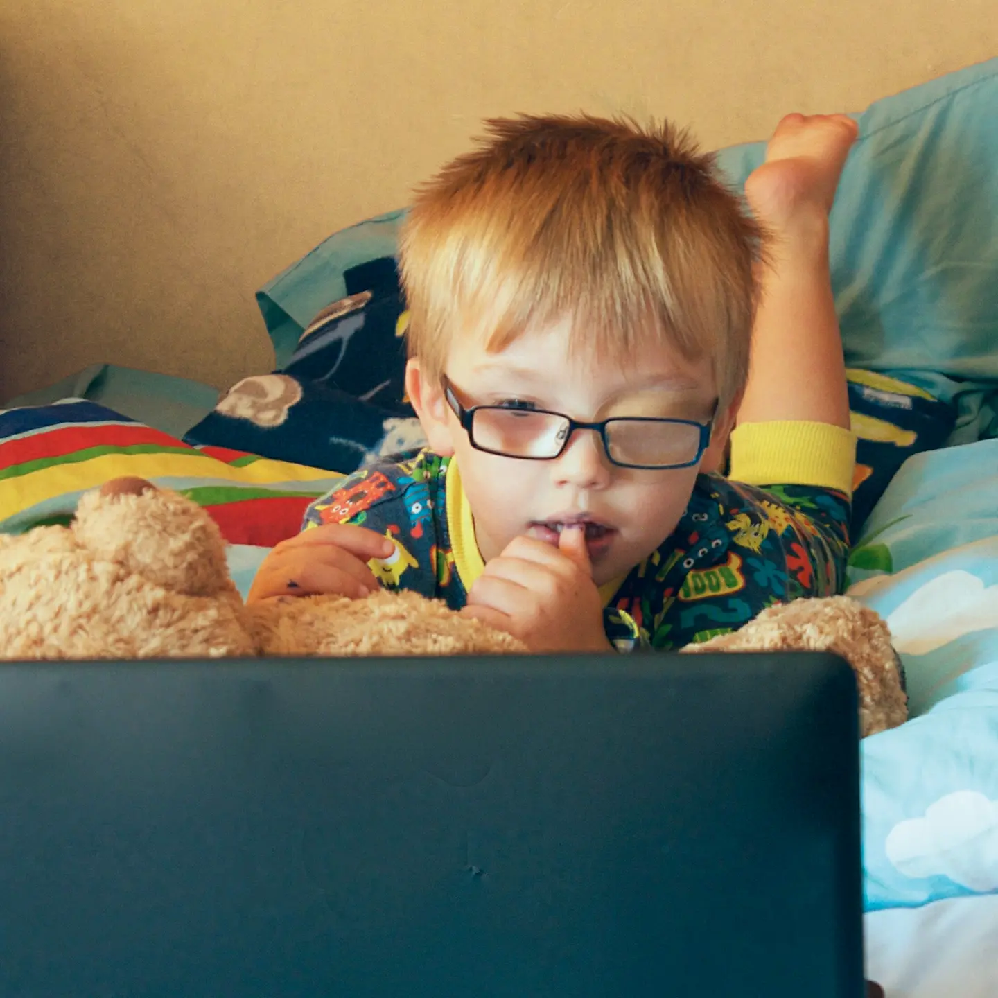 Ein kleiner Junge mit Pflaster auf dem Auge auf einem Bett