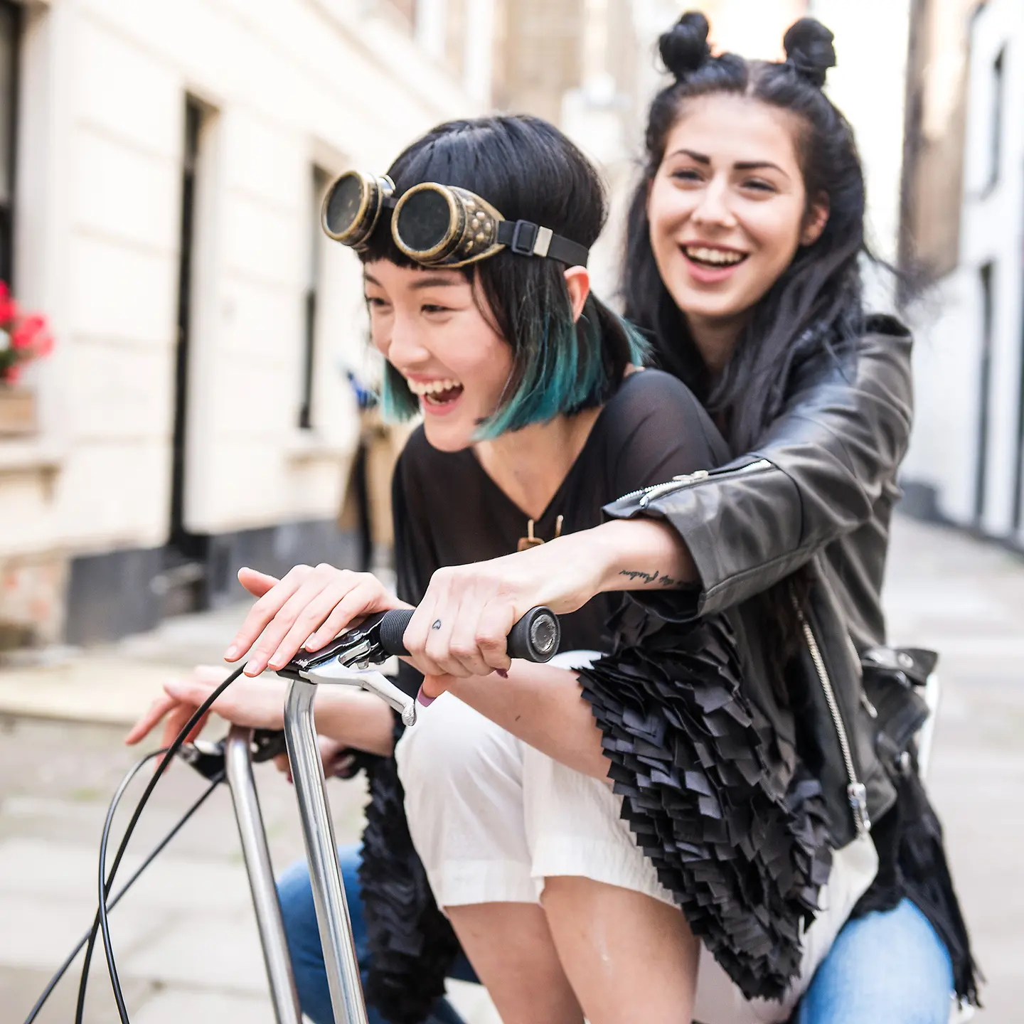 两位年轻的女大学生一起骑着同一辆自行车