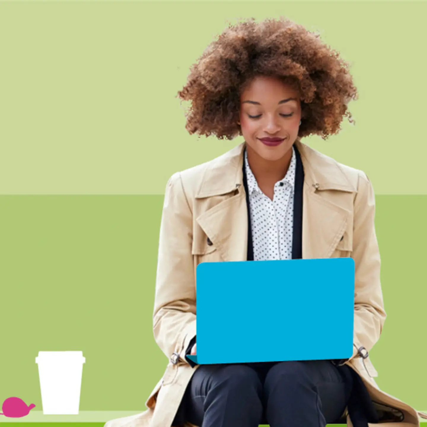 Eine Frau sitzt vor einem grünen Hintergrund und schaut auf ihren Laptop_Ausschnitt