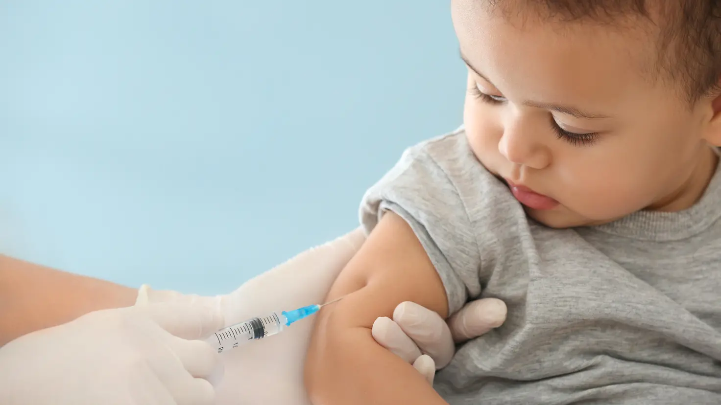 Ein Kleinkind wird mit einer Nadel im Oberarm geimpft