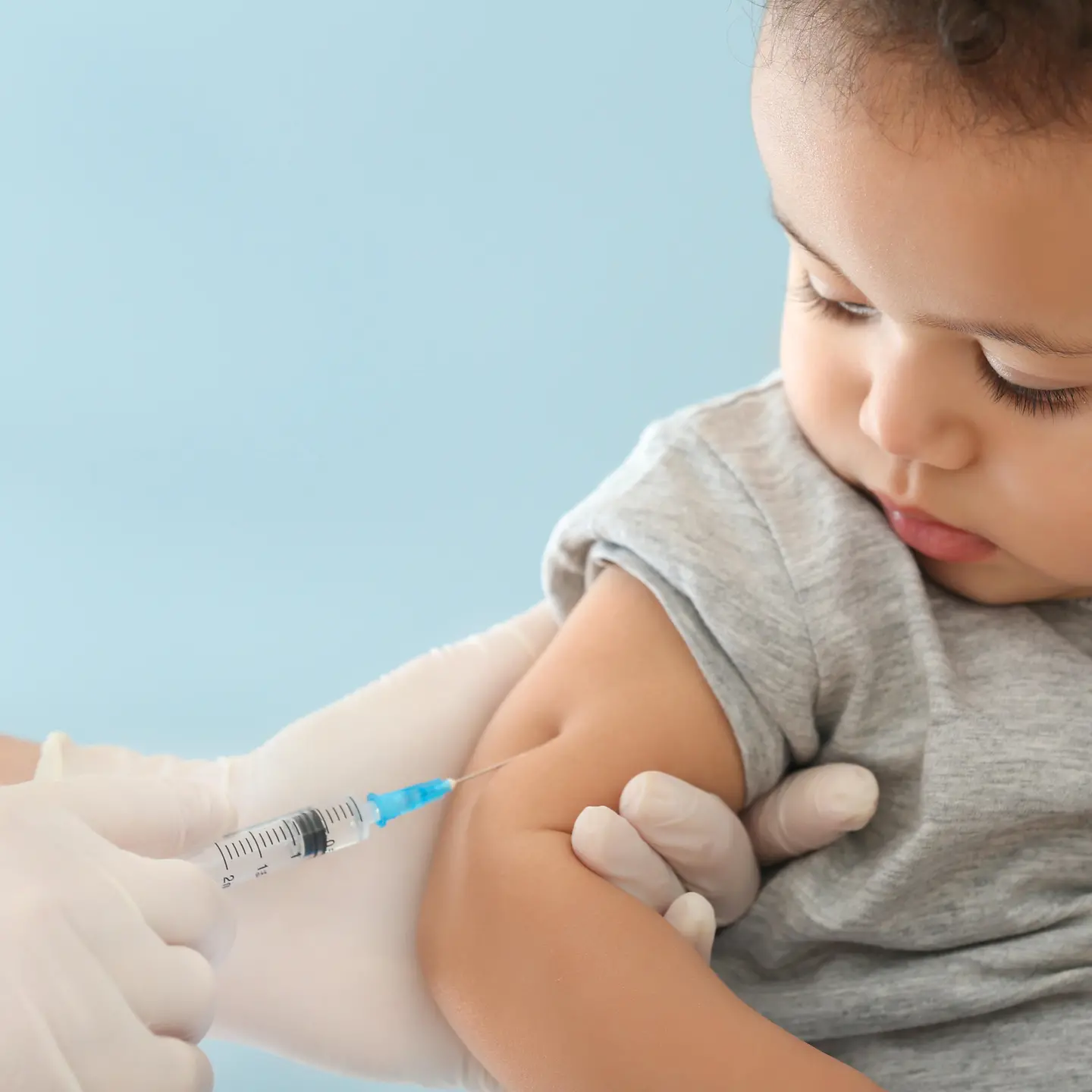 Ein Kleinkind wird mit einer Nadel im Oberarm geimpft