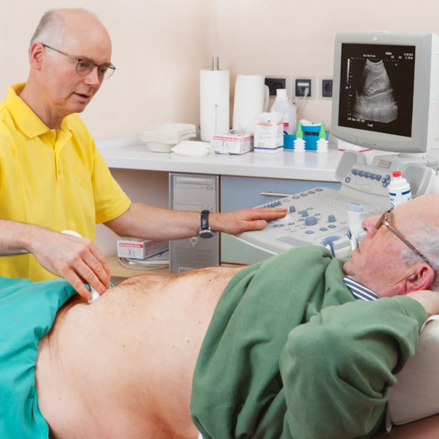 Ein Arzt führt an einem Patienten eine Ultraschalluntersuchung durch.