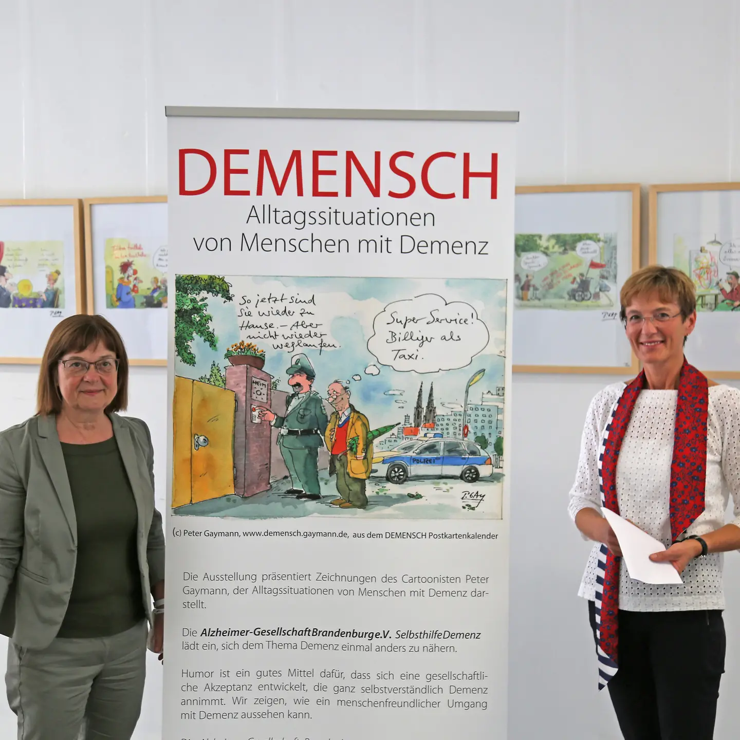 Gesundheitsministern Nonnemacher und Barmer-Landesgeschäftsführerin Leyh vor einem Hinweisschild zur Ausstellung DEMENSCH